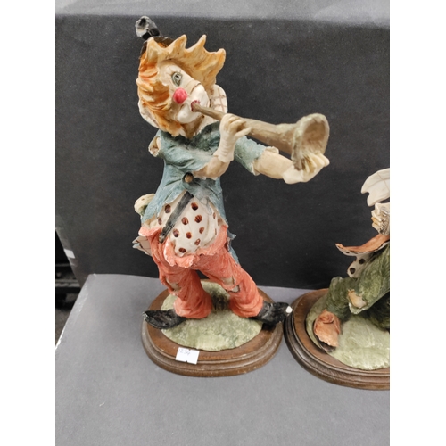 450 - A pair of resin clowns playing instruments. Clown with trumpet has small chip on foot.