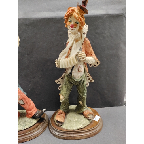 450 - A pair of resin clowns playing instruments. Clown with trumpet has small chip on foot.