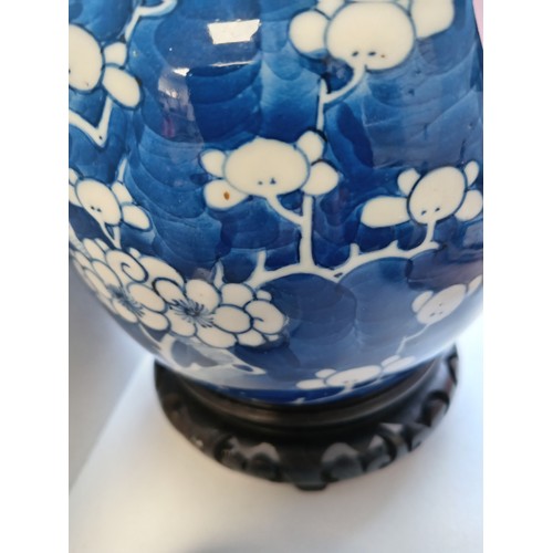 406 - Oriental Chinese blue and white prunus ginger jar on carved wooden stand H 19cm x W 13cm damage to l... 