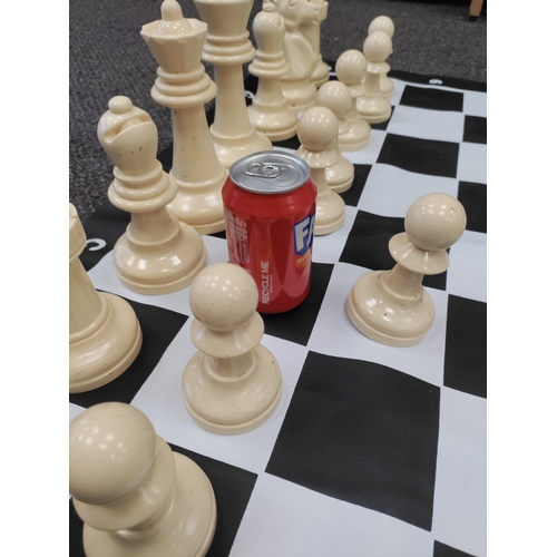 417 - Complete large plastic chess set. Small tear on D,1.  Board H 90cm x W 90cm