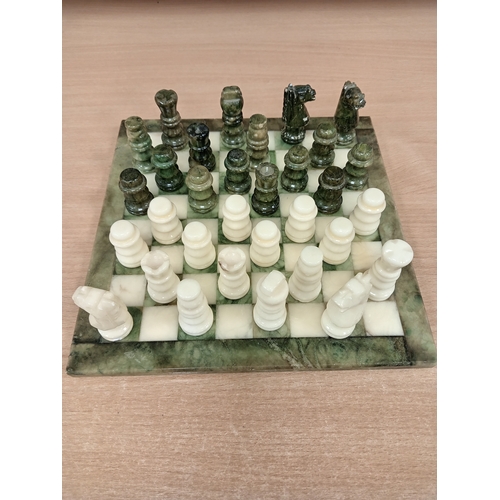 440 - Marble miniature chess board with full chess set pieces 24cm x 24cm