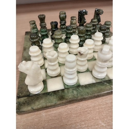 440 - Marble miniature chess board with full chess set pieces 24cm x 24cm