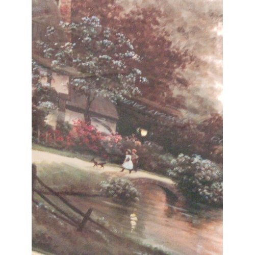 558 - Ornate framed print of a cottage by the river with children and dog. H 58CM x W 69cm