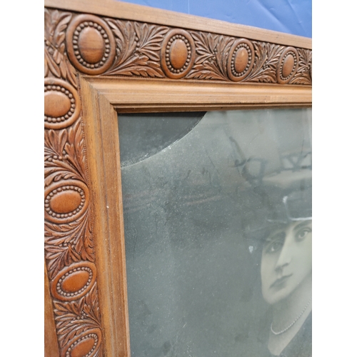 590 - A antique French photo of a woman in a carved wood frame. Glass broken in top left corner.