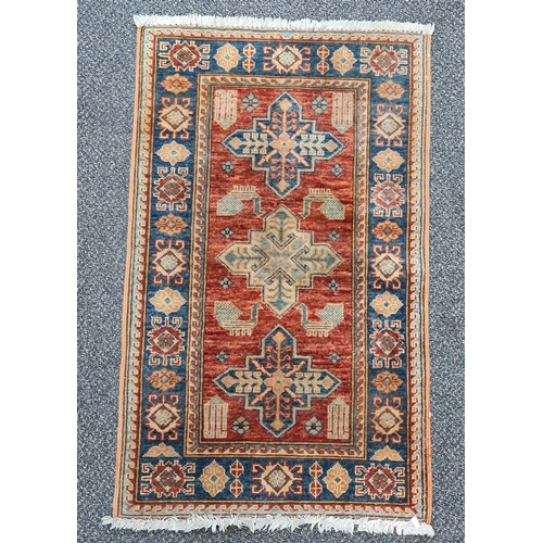 501 - Vintage Brick Red & Blue Patterned Persian/ Kazak Rug. Measures 100cm x 60cm.