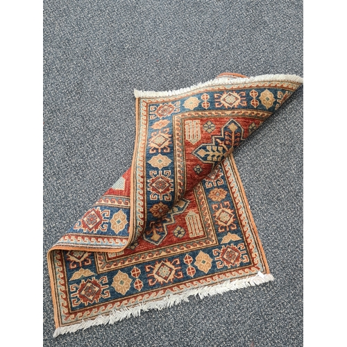 501 - Vintage Brick Red & Blue Patterned Persian/ Kazak Rug. Measures 100cm x 60cm.