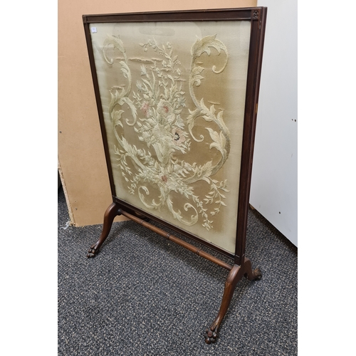 509 - Wooden fire screen guard with claw-foot feet and an embroidered floral pattern; Colours faded. Measu... 