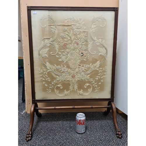 509 - Wooden fire screen guard with claw-foot feet and an embroidered floral pattern; Colours faded. Measu... 