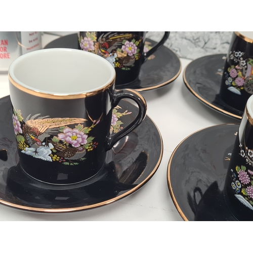 513 - Japanese black floral painted coffee set to include 6 cups with saucers. One cup AF