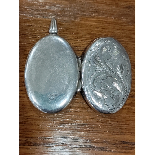 655 - An engraved silver locket stamped Silver L&N. Weight