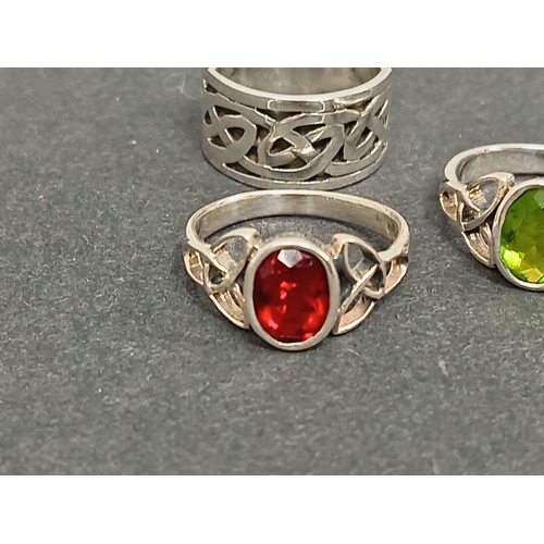 693 - Three celtic 925 silver rings, one with red stone size M, one green stone size L and a celtic band r... 