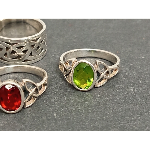 693 - Three celtic 925 silver rings, one with red stone size M, one green stone size L and a celtic band r... 