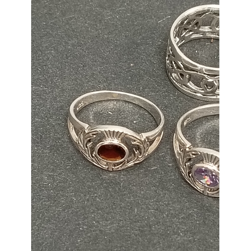 696 - Two 925 silver thistle rings one with red stone size K and lilac stone size T and a celtic band ring... 