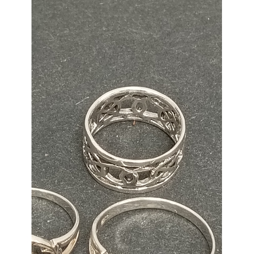 696 - Two 925 silver thistle rings one with red stone size K and lilac stone size T and a celtic band ring... 