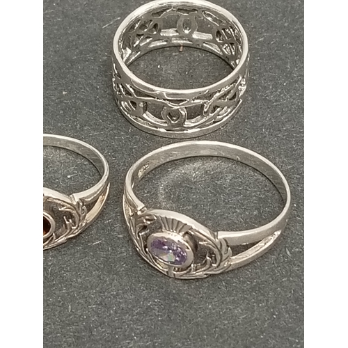 696 - Two 925 silver thistle rings one with red stone size K and lilac stone size T and a celtic band ring... 