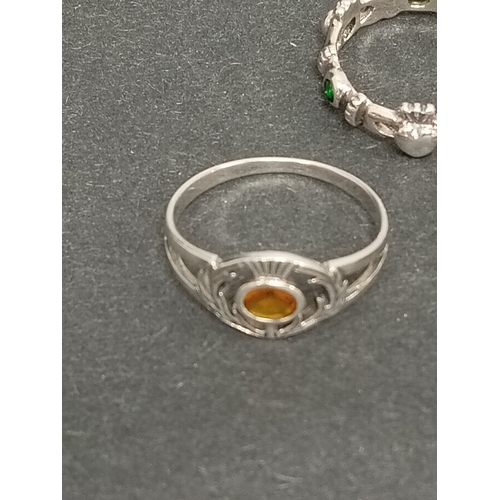 697 - Two 925 silver thistle rings one with red stone size T and one with orange stone size S and a green ... 