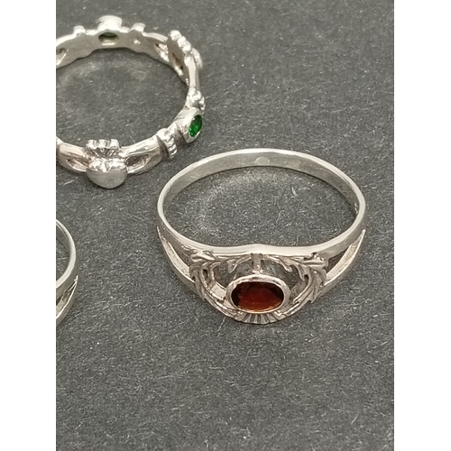 697 - Two 925 silver thistle rings one with red stone size T and one with orange stone size S and a green ... 