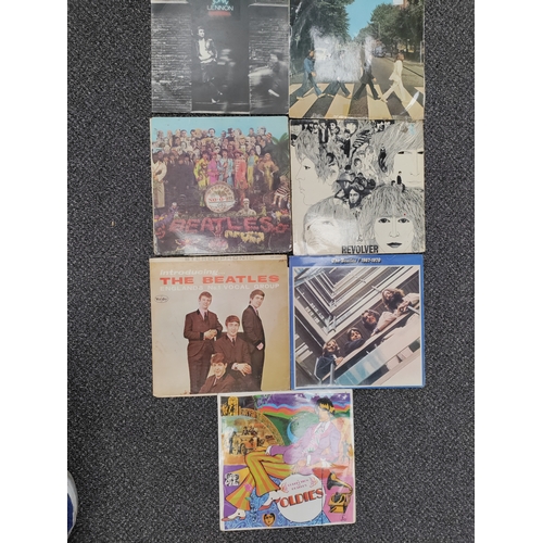 610 - A collection of 7 Beatles and John Lennon vinyl record albums. In varied condition.