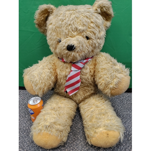 573 - A large vintage teddy bear in a tie, needs a good wash.