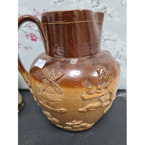 576 - Royal Doulton Lambeth salt glazed water jug with country scene and Crown Devon musical mug of John P... 