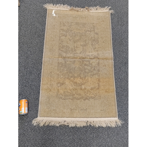 580 - A vintage brown and cream silk rug with tassels picturing men with swords on horse back.