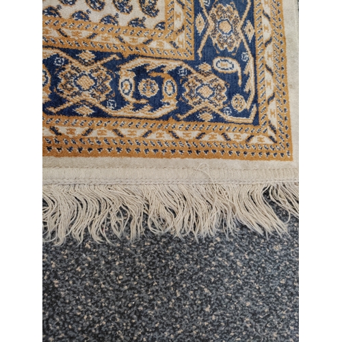 581 - A vintage paisley patterned silk rug with tassels. H 120cm x W 68cm