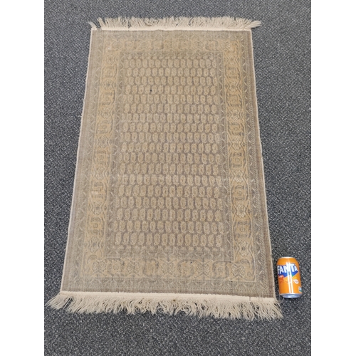 581 - A vintage paisley patterned silk rug with tassels. H 120cm x W 68cm