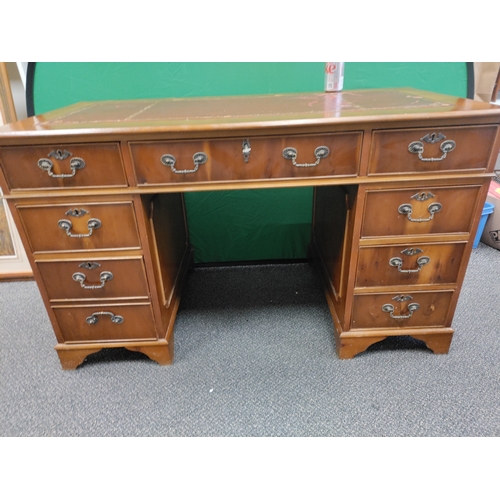 598 - A large red leather topped wooden desk with 9 drawers and original key, desk comes apart into 3 sect... 