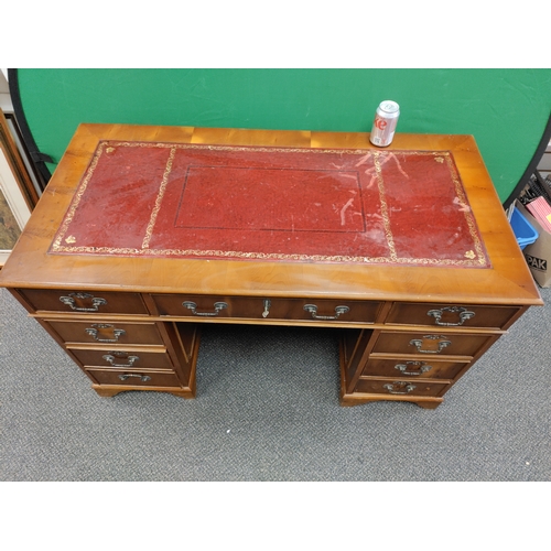 598 - A large red leather topped wooden desk with 9 drawers and original key, desk comes apart into 3 sect... 