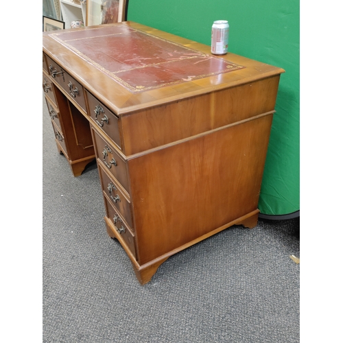 598 - A large red leather topped wooden desk with 9 drawers and original key, desk comes apart into 3 sect... 