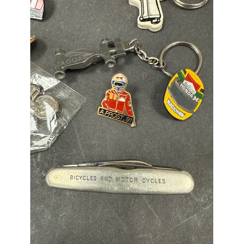 638 - Collection of formula one and motoring key rings, pin badges, a pen knife and more. Included is a En... 