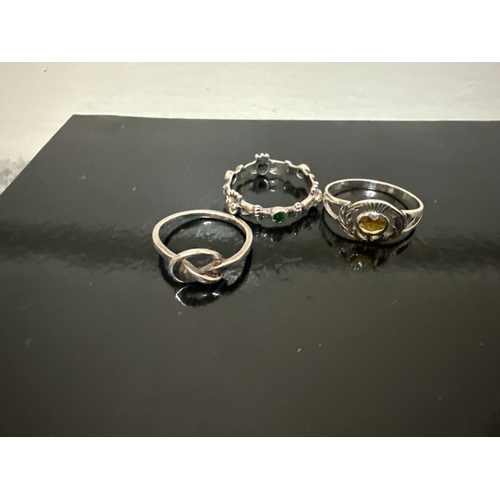 717 - 3 925 silver rings. One knot style, one with green stones and hearts and one with an amber coloured ... 