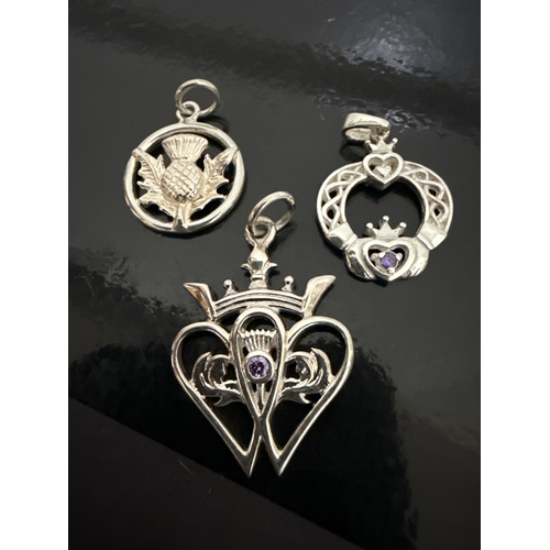 720 - 3 925 silver pendants. One Scottish thistle  style, one ornate with an amethyst colour stone and the... 