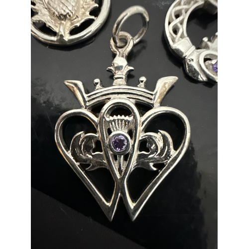 720 - 3 925 silver pendants. One Scottish thistle  style, one ornate with an amethyst colour stone and the... 