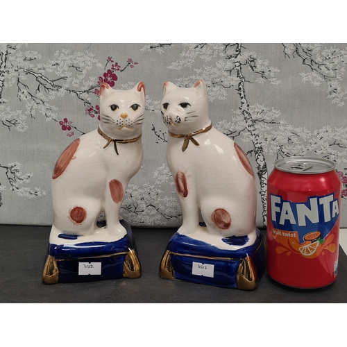 438 - Pair of white & ginger ceramic Cats with blue & gilt bases. Each measures H29cm x W10cm