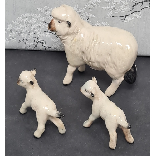 427 - Family of ceramic sheep, Ewe is marked Beswick and 2 lambs marked England.