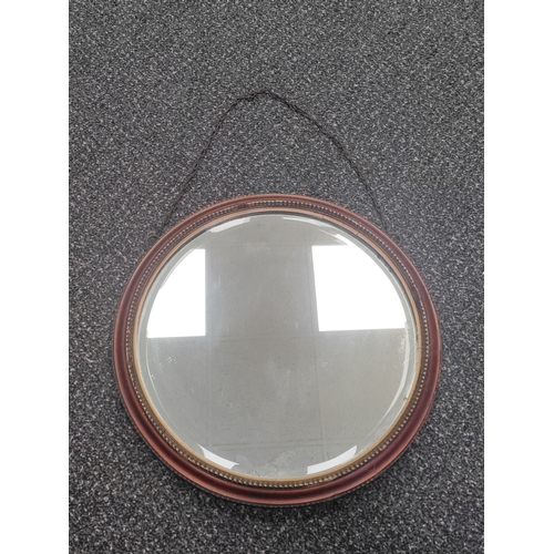 507 - A round antique Edwardian bevelled edge mirror. Diameter 34cm.