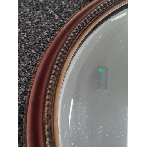 507 - A round antique Edwardian bevelled edge mirror. Diameter 34cm.