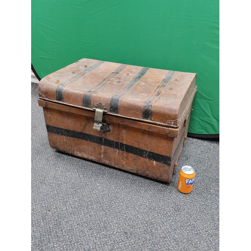 547 - A large brown and black antique metal trunk; Latch stamped E.Bates Wolverhampton lever.