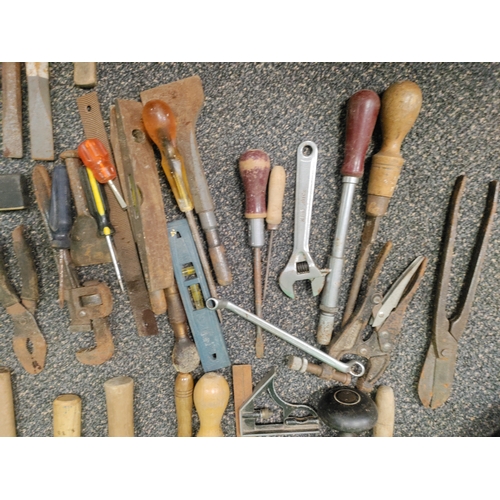 553 - A large assortment of tools to include hammers, chisels, set squares, spirit levels, screw drivers, ... 