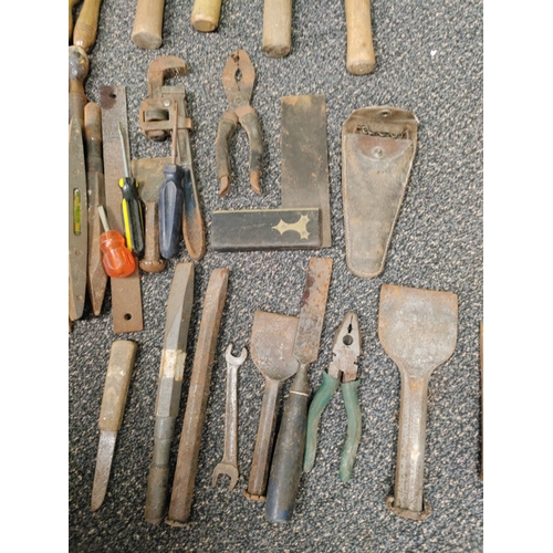 553 - A large assortment of tools to include hammers, chisels, set squares, spirit levels, screw drivers, ... 