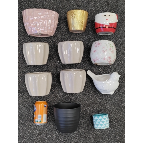 516 - An assortment of 11 plant pots. Collection consists  of floral, bird, Santa and many more.