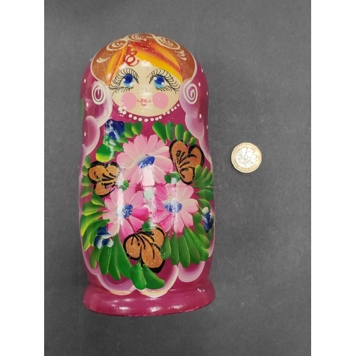 532 - A nest of 5 Russian purple wooden nesting dolls with floral patterns