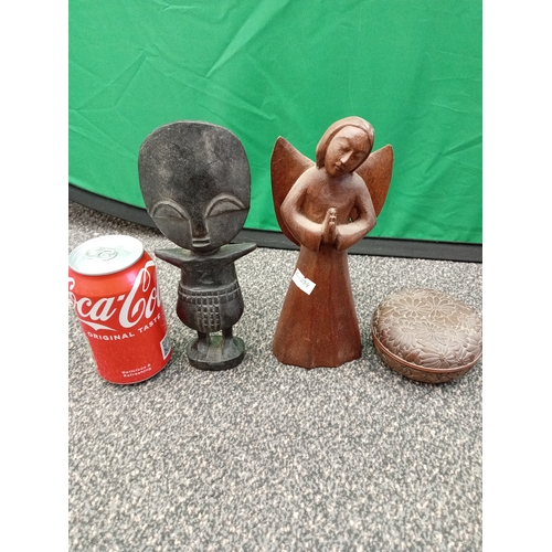 668 - A trio of wooden carvings. To include a tribal African figure, an angel figurine and small floral de... 