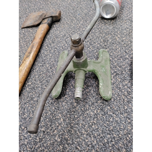 669 - A trio of vintage tools. To include a hand axe, hand drill and an aluminium sprinkler.