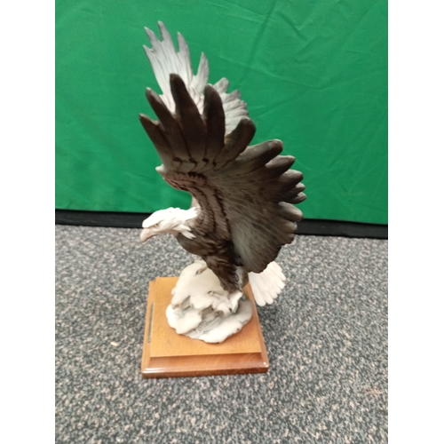 678 - Giuseppe Armani 'Eagle on snow' #175 C retired figurine. On a mahogany wood stand.