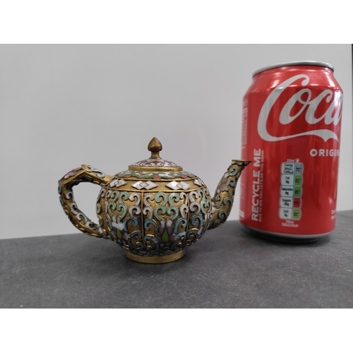 692 - A miniature cloisonne teapot with oriental pattern. H 6cm x 12cm.