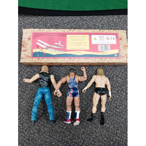 710 - Flying rubber powered model plane and three WWE figures, including Kurt Angle and Triple H.