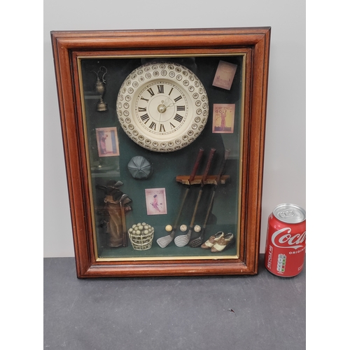 711 - A working clock with a golfing display. H 40cm x W 31cm.