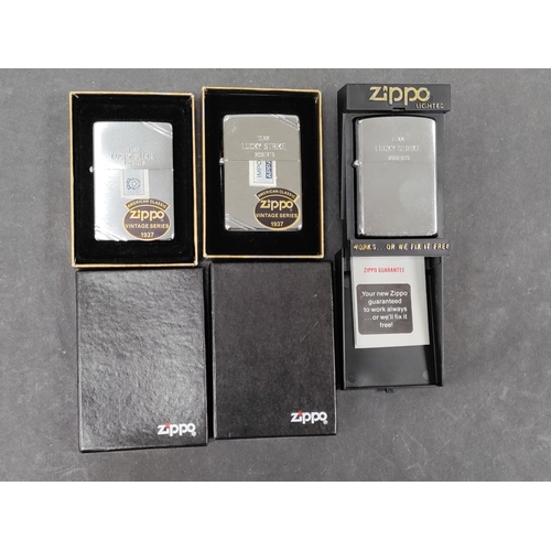 729 - A trio of brand new Zippo lighters with original seals, engraved 